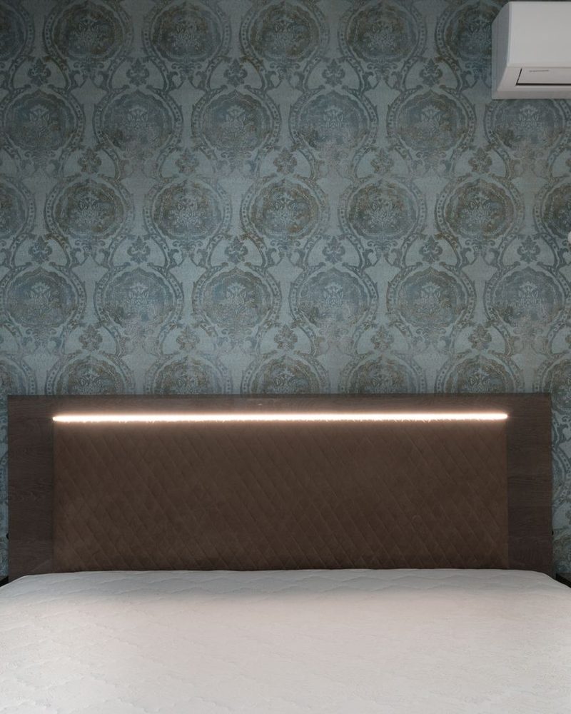 Contemporary bedroom with a dark teal art-deco patterned accent wall behind the bed