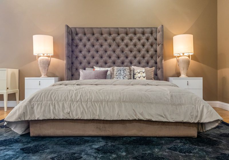 Modern bedroom with a mauve tufted headboard and warm neutral walls