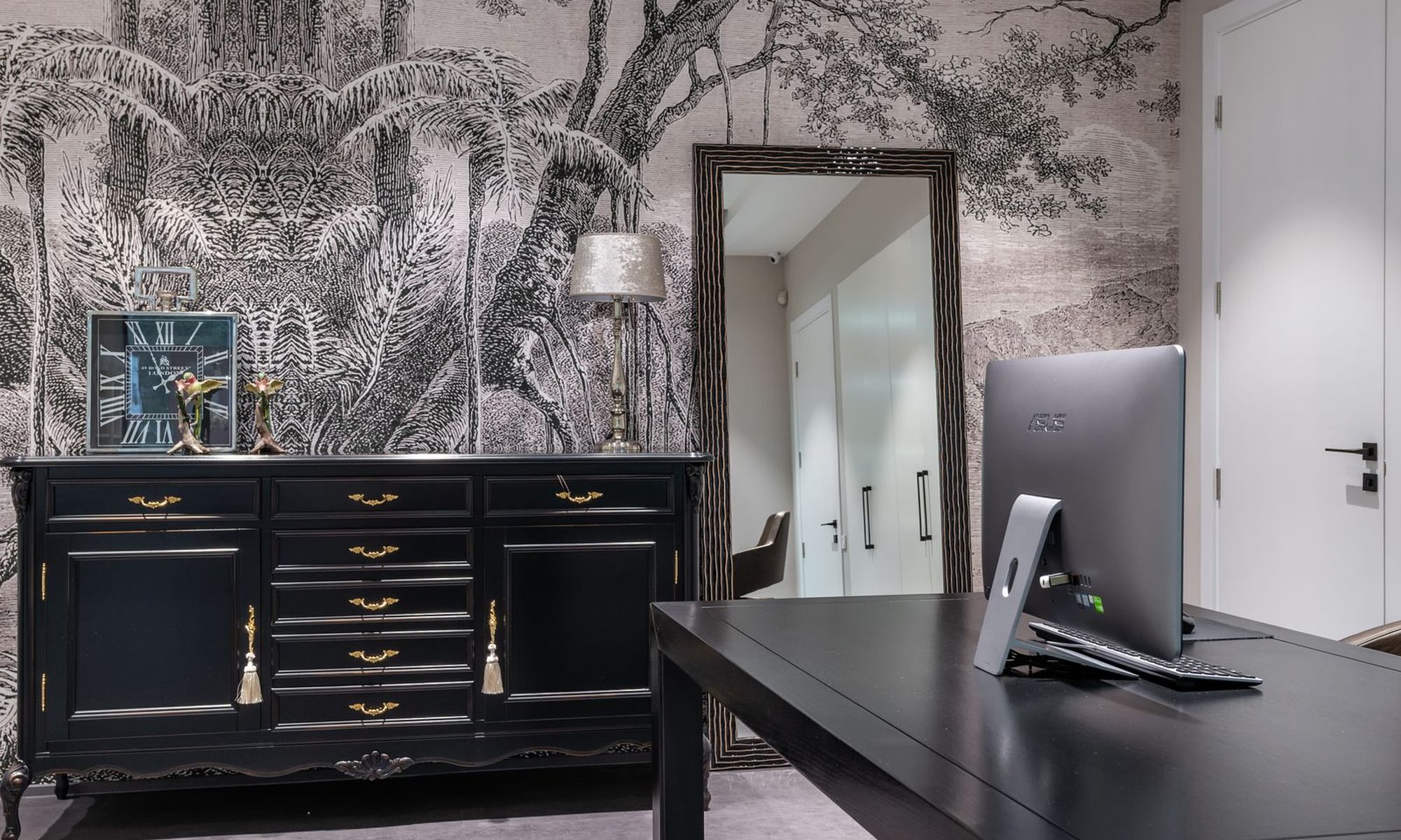 Designer scenic mural wallpaper installed across a residential feature wall with a dresser and tall mirror